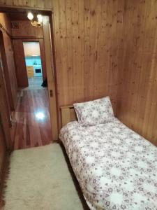 イオアニナにあるIoannina Traditional Houseの木製の壁の客室の小さなベッド1台