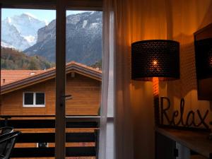 a lamp next to a window with a view of a mountain at S&P Mountain View Apartment 2 in Wilderswil
