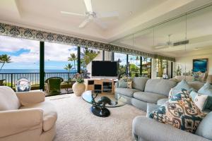 Makena Surf- CoralTree Residence Collection في ويليا: غرفة معيشة مع كنب وتلفزيون بشاشة مسطحة
