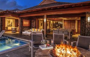 an outdoor patio with a fire pit and a living room at The Lodge at Kukui’ula in Koloa