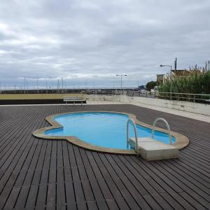 a small swimming pool on a wooden deck at Black'nYellow Place in Vila Franca do Campo