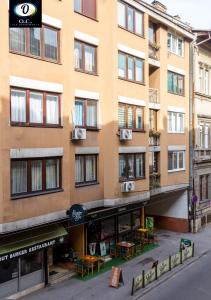 サラエボにあるO..C.. Lux Apartmentsの目の前にテーブルと椅子が置かれた高層ビル