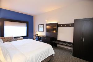 a hotel room with a bed and a flat screen tv at Holiday Inn Express Hotel & Suites Ashland, an IHG Hotel in Ashland