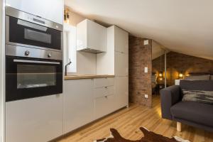 La cuisine est équipée de placards blancs et d'un four noir. dans l'établissement LxFactory Apartment, à Lisbonne