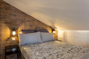 Ce lit se trouve dans une chambre dotée d'un mur en briques. dans l'établissement LxFactory Apartment, à Lisbonne
