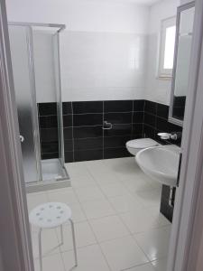 une salle de bains avec douche, lavabo et toilettes dans l'établissement Appartamenti STELLA MARINA- Posto Rosso, à Alliste