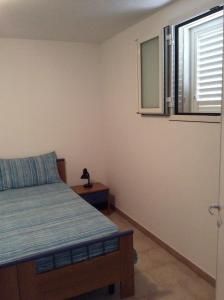 une chambre avec un lit et une fenêtre dans l'établissement Appartamenti STELLA MARINA- Posto Rosso, à Alliste