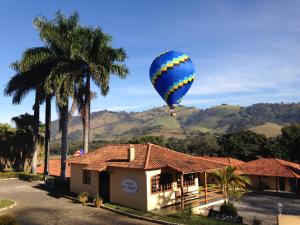 Une montgolfière survole une maison dans l'établissement Pousada Le Sapê, à São Lourenço