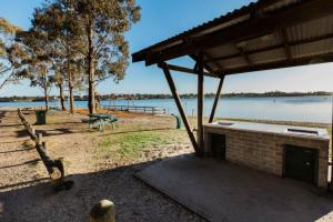 a pavilion with a picnic table next to a lake at Above Sunset in Paynesville