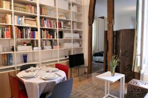 a dining room with a table and bookshelves at Appartment near Louvre, central in Paris