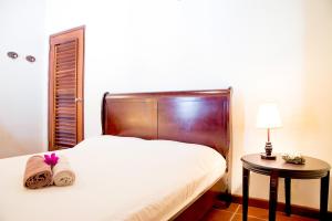 ein Schlafzimmer mit einem Bett und einem Tisch mit einer Lampe in der Unterkunft Pelican Villa in Lagun