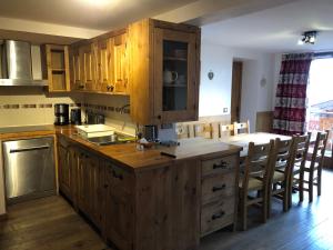 cocina con armarios de madera y encimera en Chalet Petite Etoile Des Neiges, en L'Alpe-d'Huez