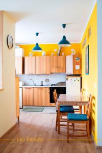 kuchnia z żółtymi ścianami, stołem i krzesłami w obiekcie Casa Bianchera w mieście Monfalcone