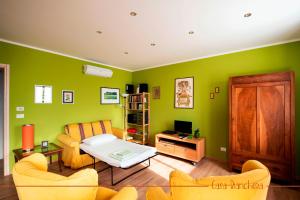 a living room with green walls and a table and chairs at Casa Bianchera in Monfalcone