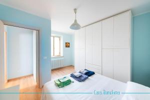 um quarto com uma cama branca e uma parede azul em Casa Bianchera em Monfalcone