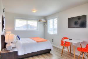 a bedroom with a bed, chair, table and a window at OCEAN SHORES RESORT - Brand New Rooms in Ocean Shores