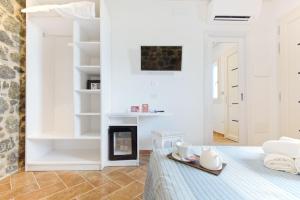 a white room with a fireplace and a table at La Roccia in Castelsardo