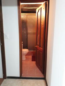 una puerta abierta a un baño con aseo en ALMANIK, en Villa de Leyva