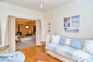 a living room with a couch and a dining room at Racecourse Villa - Classic 1935 Charm & Space in Christchurch