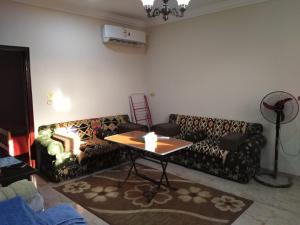 a living room with two couches and a table at Pyramids View Apartment in Cairo