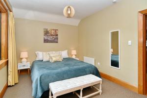 a bedroom with a large bed with a blue blanket at Racecourse Villa - Classic 1935 Charm & Space in Christchurch