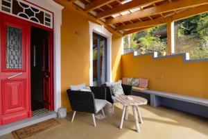 a red door on a porch with chairs and a table at Dazk Golden Estate in Ribeira Brava