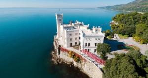 a large white building on the edge of the water at Casa Bianchera in Monfalcone