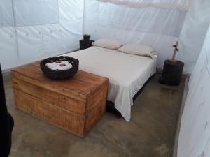 1 dormitorio con cama y mesa de madera en El Nómada Hostel en Palomino