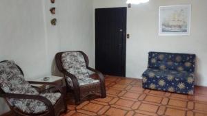 sala de estar con 2 sillas, silla y taburete en Apartamento Aconchegante, en Bombinhas