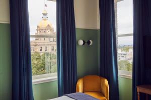 a bedroom with a window with a view of a building at The Drayton Hotel Savannah, Curio Collection by Hilton in Savannah +44 photos
