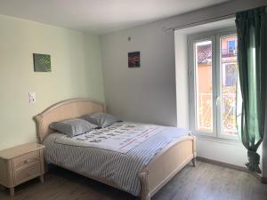 a bedroom with a bed and a large window at Formidable Studio au cœur historique de Fréjus in Fréjus