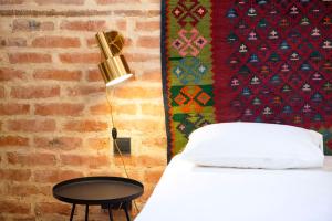 a bedroom with a bed with a lamp and a table at Funicular Inn Apartments in Tbilisi City +82 photos