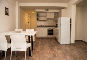 cocina con nevera blanca, mesa y sillas en La Bonita Apartment en San Carlos de Bariloche