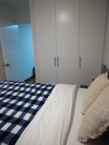 1 dormitorio con cama a cuadros y armarios blancos en Hope San Isidro, en Lima