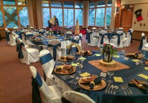 a banquet hall with blue tables and white chairs at Cape Fox Lodge in Ketchikan