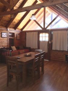Una sala de estar con una mesa y sillas y un sofá. en La Posada, en Villa Ventana