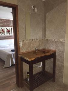 y baño con lavabo de madera y espejo. en La Posada en Villa Ventana