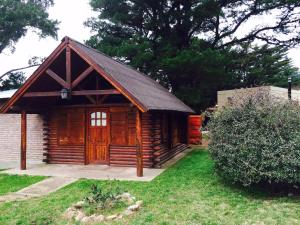 Cabaña de madera con puerta grande en un patio en La Posada, en Villa Ventana 15 fotos más