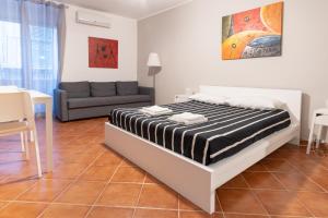 um quarto com uma cama e um sofá em Madinah apartments em Palermo