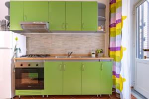 uma cozinha com armários verdes e um lavatório em Madinah apartments em Palermo