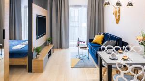 un soggiorno con divano blu e una sala da pranzo di Rakowicka 20h Apartments by LET'S KRAKOW a Cracovia