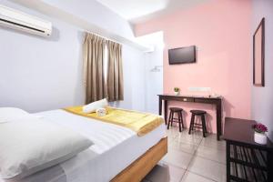 Dormitorio con cama, escritorio y TV en Hotel Oriental, en Inanam