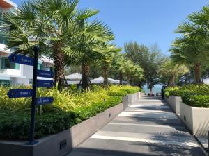 a sidewalk with street signs and palm trees at Bay Window at Sea in Cha Am