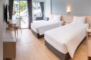um quarto de hotel com duas camas e uma mesa em Bay Window at Sea em Cha Am