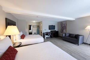 a hotel room with two beds and a couch at SureStay Hotel by Best Western Castlegar in Castlegar