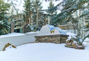 a sign in the snow in front of a building at Top of the Village - CoralTree Residence Collection in Snowmass Village
