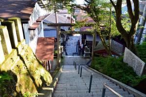een trap naar een gebouw met een huis bij Hotel Ikaho Ginsui in Shibukawa