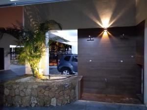 a car parked in a garage with a palm tree at Apto Novo a uma Quadra da Praia in Guarujá