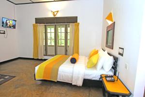 a bedroom with a large bed with yellow pillows at Train View Chalet in Bandarawela