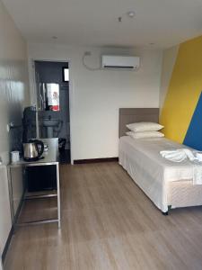 um quarto com uma cama e uma cozinha em Magarbo Hotel em Boracay